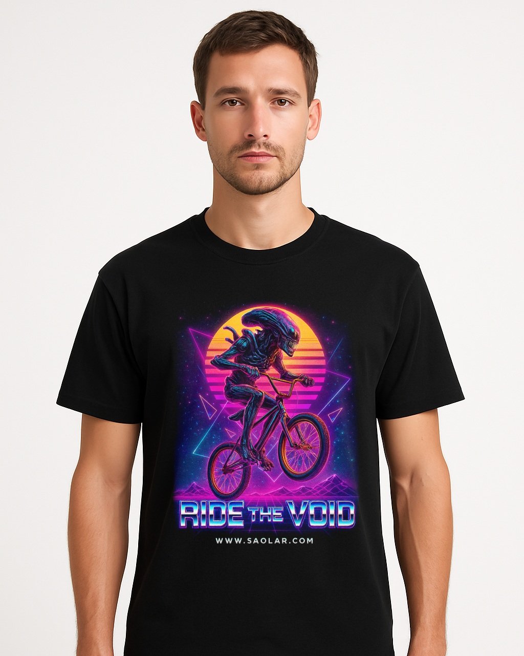 Men’s black t-shirt featuring a retro neon design of an alien riding a BMX bike with glowing synthwave sunset background and the text 'RIDE THE VOID' and 'www.saolar.com