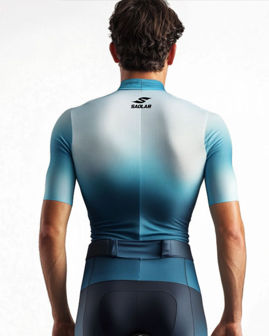 Cyclist wearing SAOLAR gradient jersey in white and blue tones.