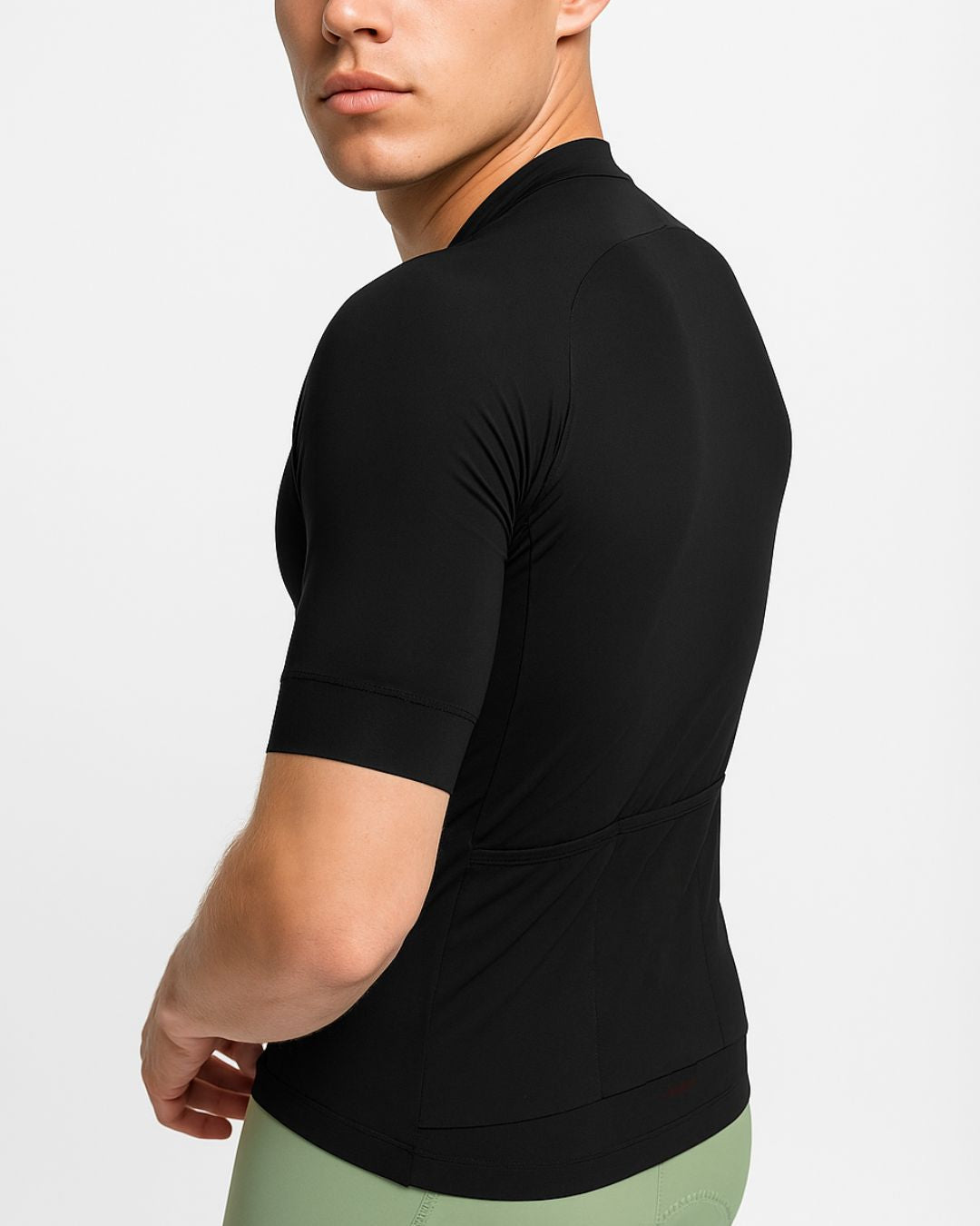 Cyclist adjusting the hem of the SAOLAR SR2 Eclipse black cycling jersey, featuring a clean, modern cut and lightweight performance fabric.