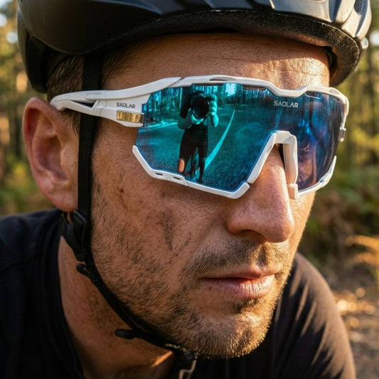 Male cyclist wearing SAOLAR Rapture ICE white sport sunglasses with Full Revo Blue photochromic lenses, paired with a black cycling helmet. Shot in a forest setting at golden hour. UV400 protection, wraparound frame, prescription-compatible — built for road cycling and outdoor performance.