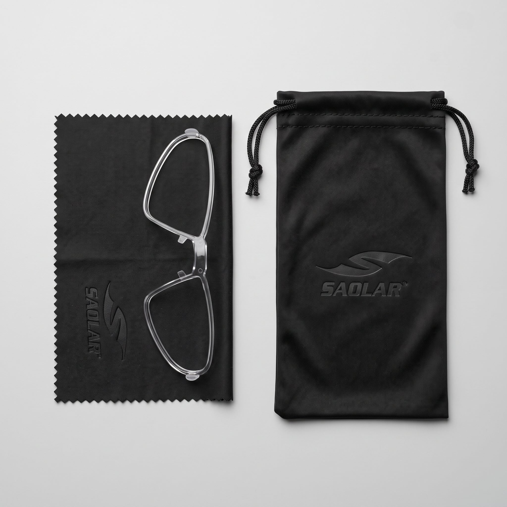 SAOLAR prescription insert frame displayed with a premium black microfiber cleaning cloth and branded drawstring pouch on a clean white background. Lightweight optical insert designed for compatible SAOLAR sports sunglasses, providing secure prescription lens support while protecting eyewear during storage, travel, cycling, running, and outdoor adventures.