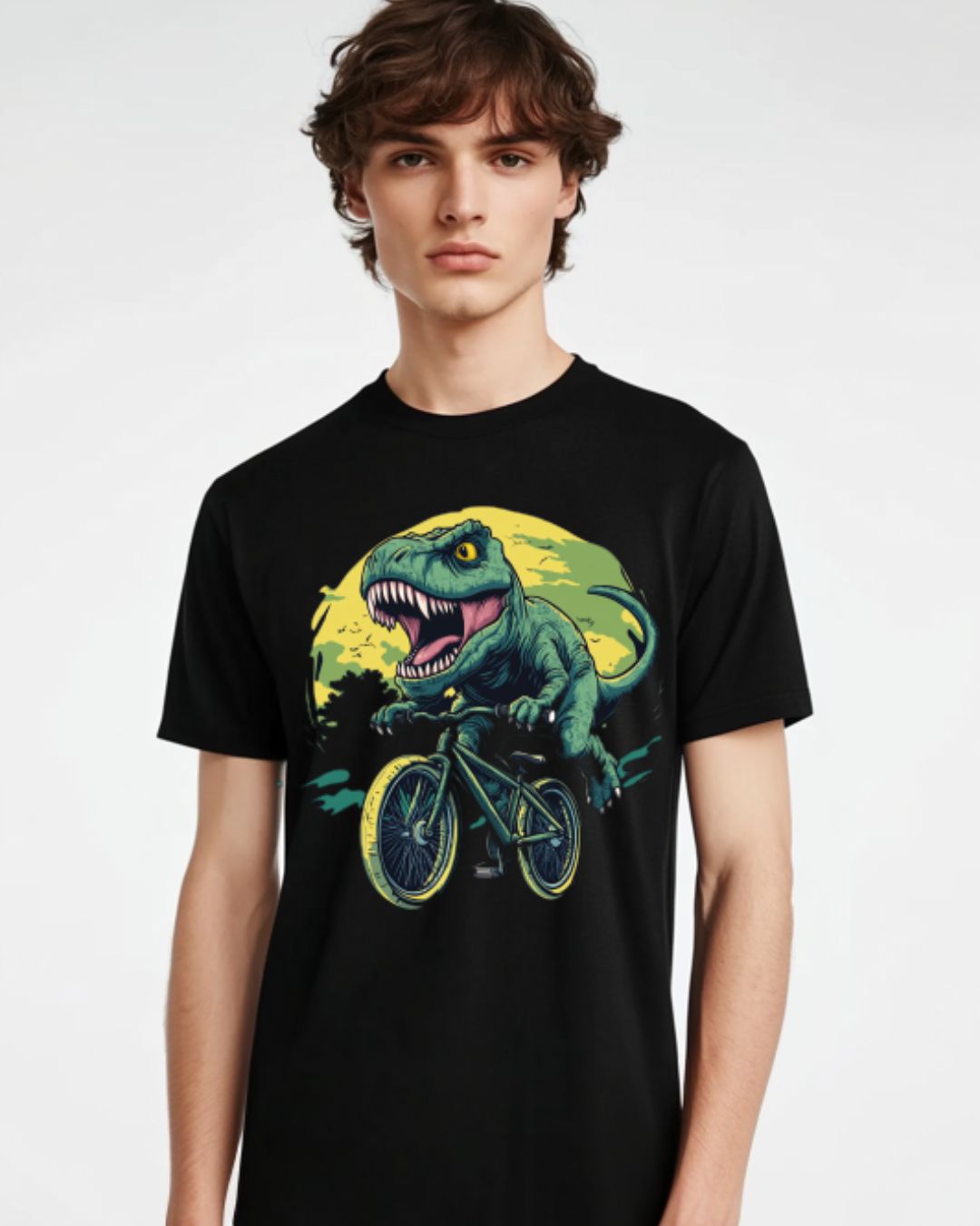 Playful T-Rex riding a bicycle under a full moon, featured on a vibrant and fun cotton graphic t-shirt.