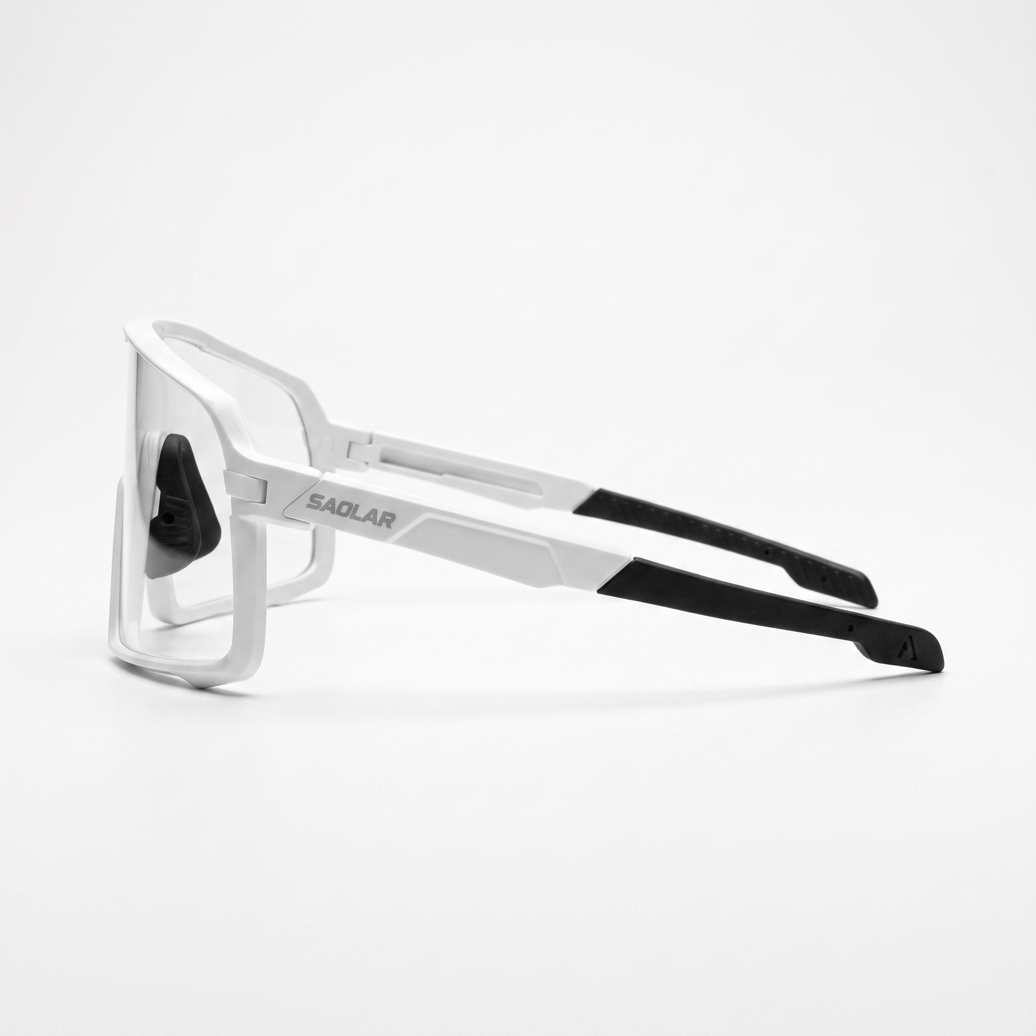 Side view of SAOLAR Shadelane photochromic cycling glasses, highlighting the white angular temples, clear adaptive lens, and black rubber temple tips. The sculpted frame has a technical, aerodynamic profile with SAOLAR branding on the side. Large wraparound lens coverage helps protect the eyes while maintaining a clean, modern cycling aesthetic.